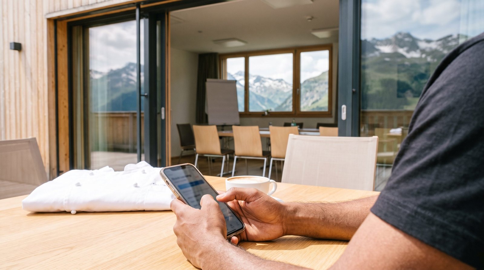 Mitarbeiter übt in der Pause auf der Sonnenterrasse mit einer Lern-App am Handy